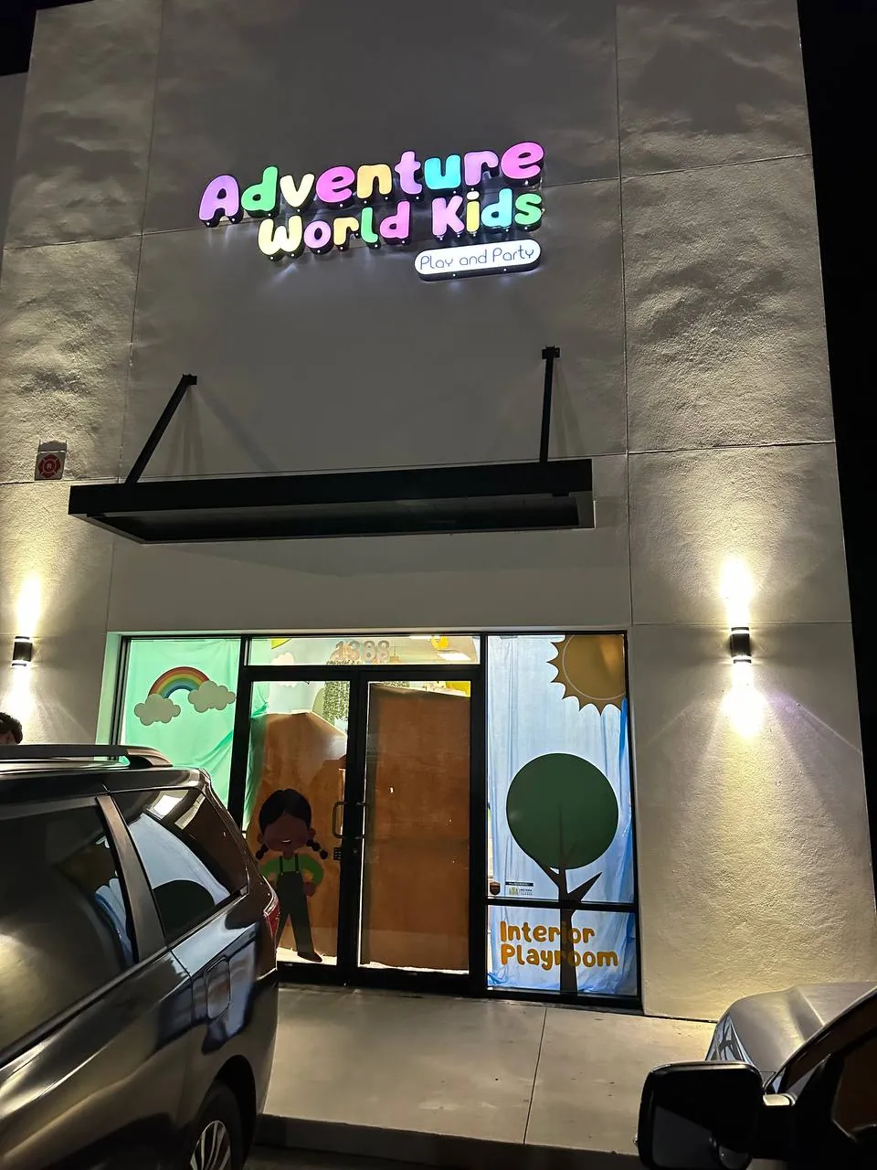 Adventure World Kids colorful illuminated letters and playroom window graphics at night