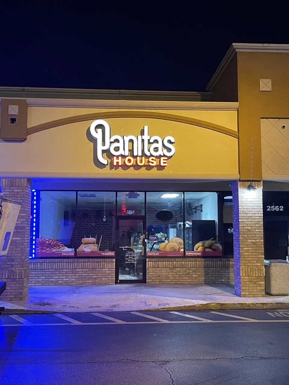 Panitas House illuminated channel letters above a bakery storefront at night