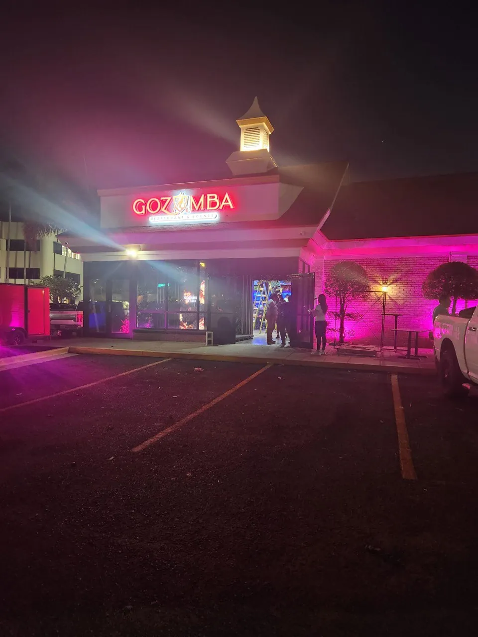 Gozamba restaurant exterior at night with red channel letters and pink accent lighting