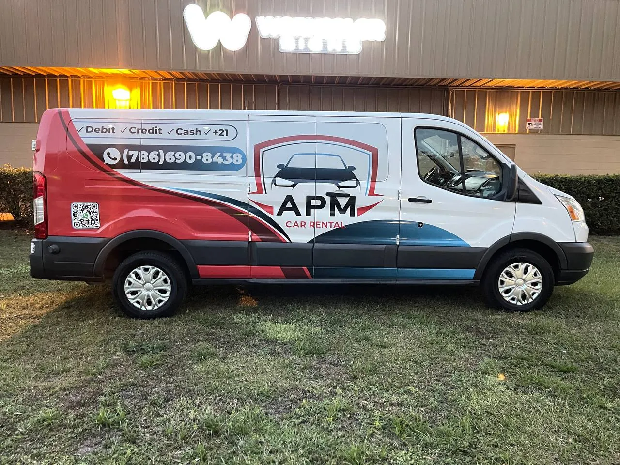 White van with a red and blue APM partial wrap