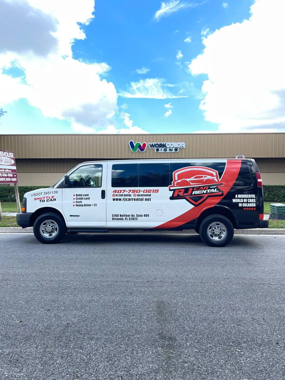 White RJ Car Rental passenger van with a red and black partial wrap parked in front of our Orlando shop