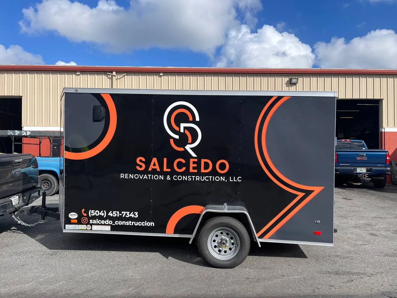 Black cargo trailer with orange Salcedo Renovation & Construction graphics