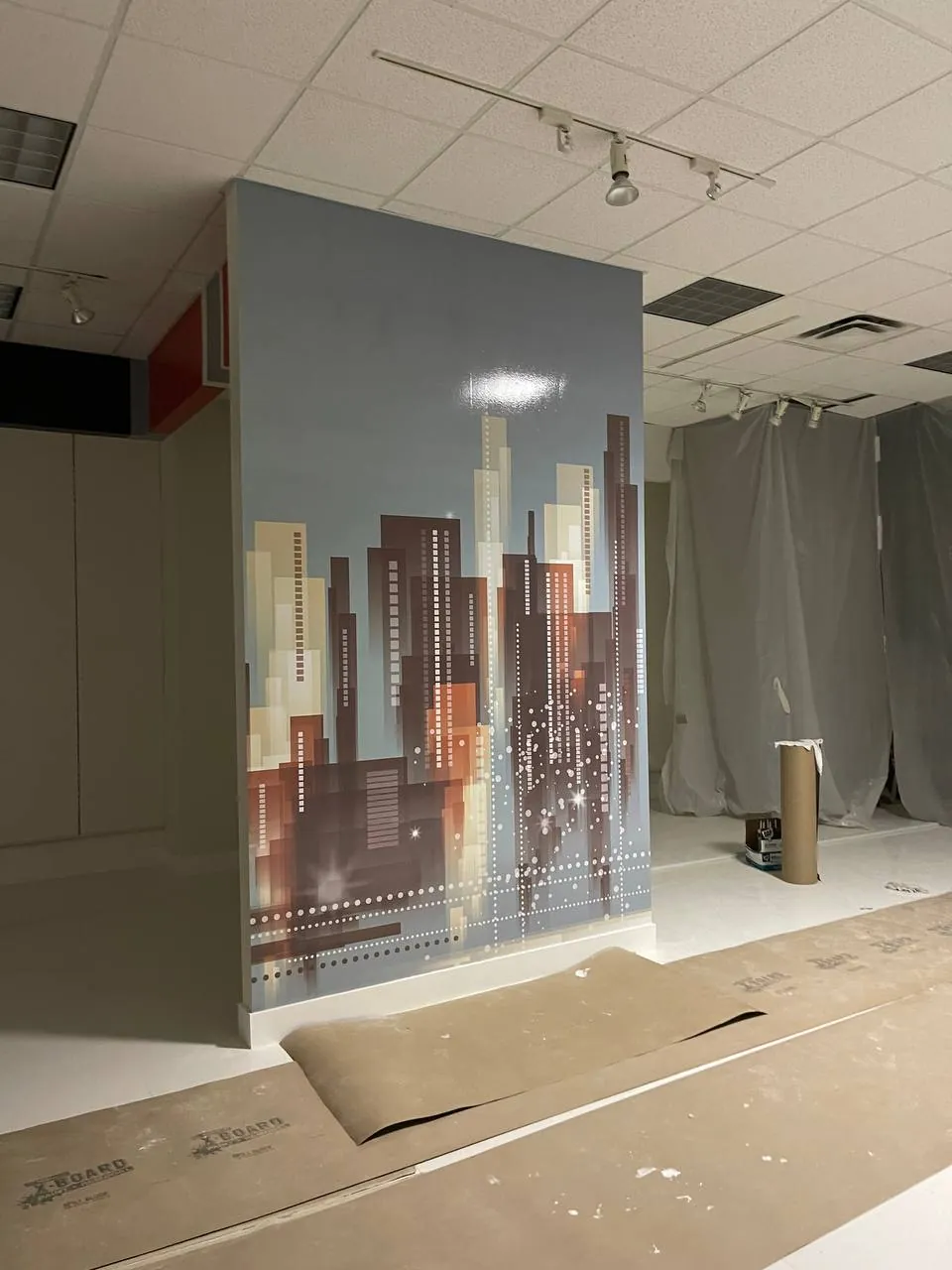 City-skyline wrap on a freestanding wall panel during installation