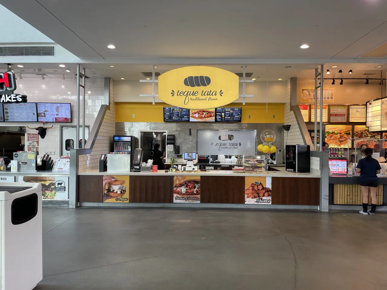 Teque Tata food-court counter with a hanging logo sign, menu boards and printed counter panels