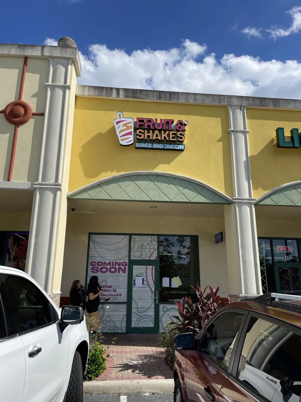 Fruit & Shakes Bowls and Juicery sign on a yellow storefront with window graphics