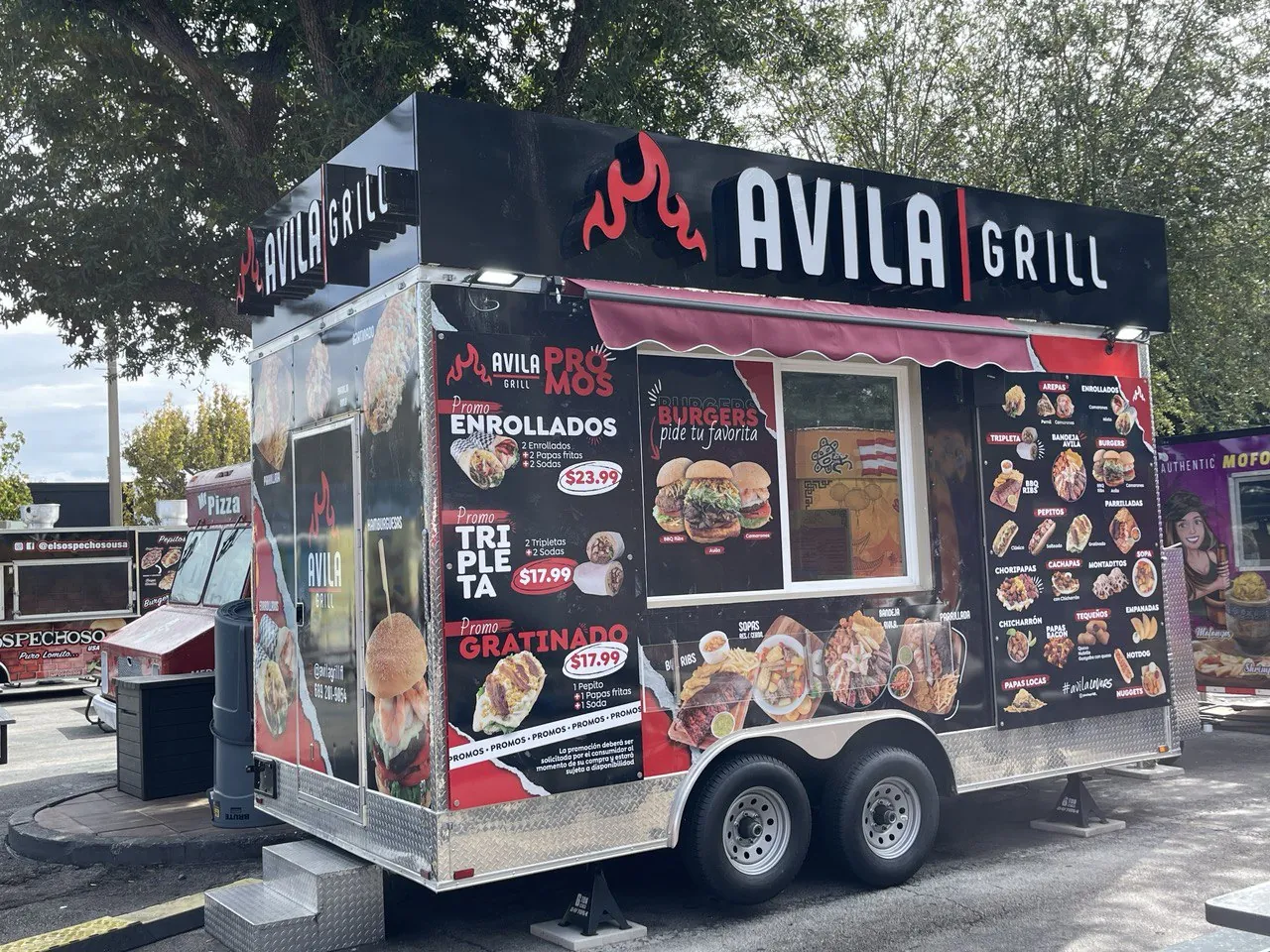 Avila Grill food trailer wrapped in black and red graphics with food photos and a printed menu